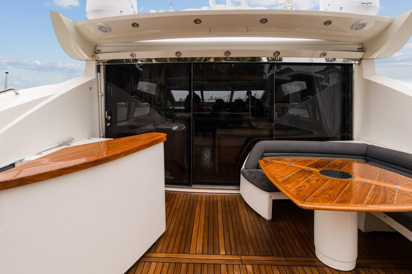 a boat with a table and a surfboard in the back aboard HER WAY Yacht for Sale