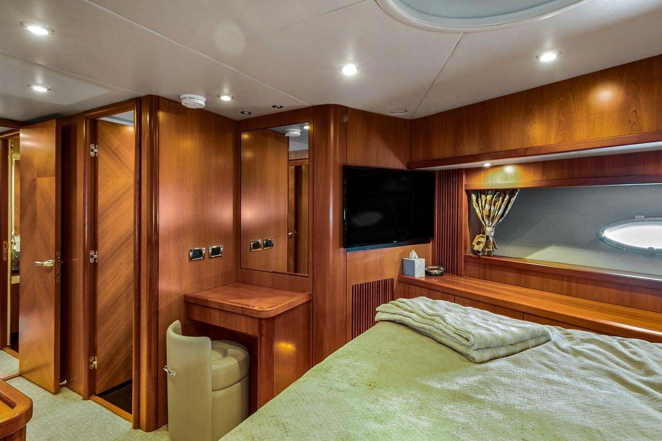 a bedroom with a bed and a television aboard HER WAY Yacht for Sale