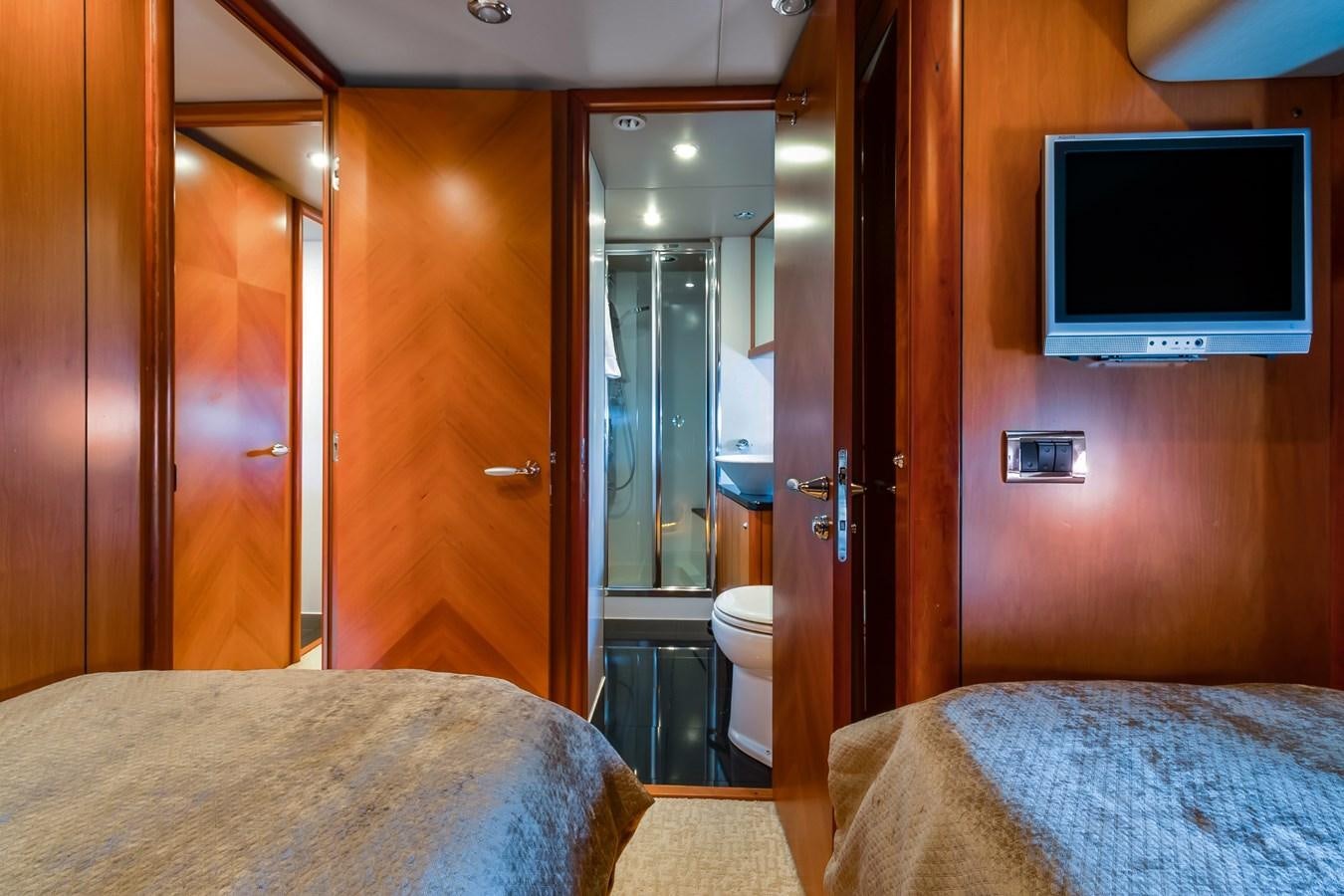a bedroom with a bed and a television aboard HER WAY Yacht for Sale
