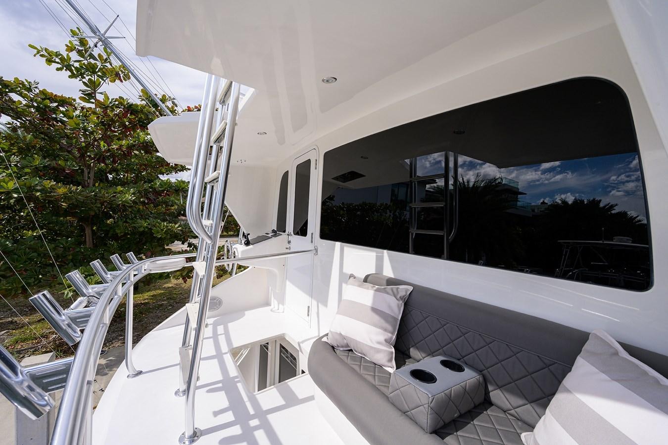 a white lounge chair on a deck overlooking a large black and white window aboard KNOT RACING Yacht for Sale