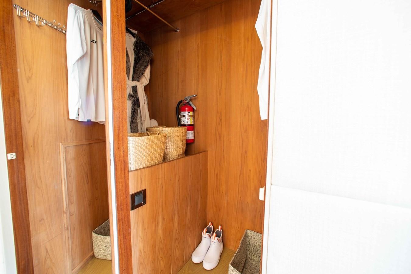 a room with a wood cabinet and a shelf with clothes on it aboard ISLAND SOUL Yacht for Sale