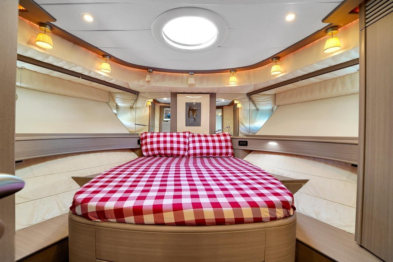 a room with a striped bed aboard PERSHING 88/07 Yacht for Sale