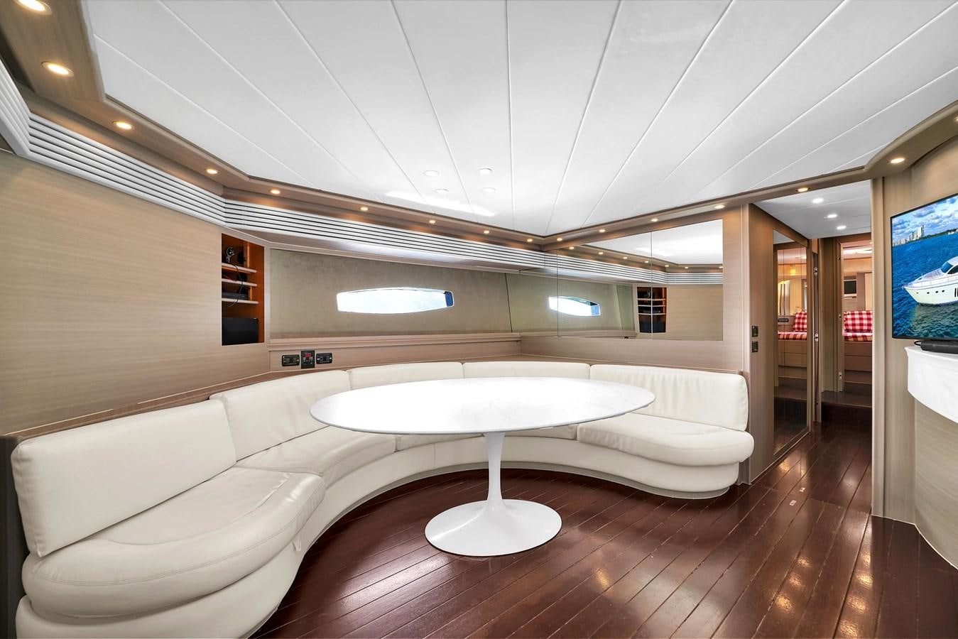 a room with a couch and a television on the wall aboard PERSHING 88/07 Yacht for Sale