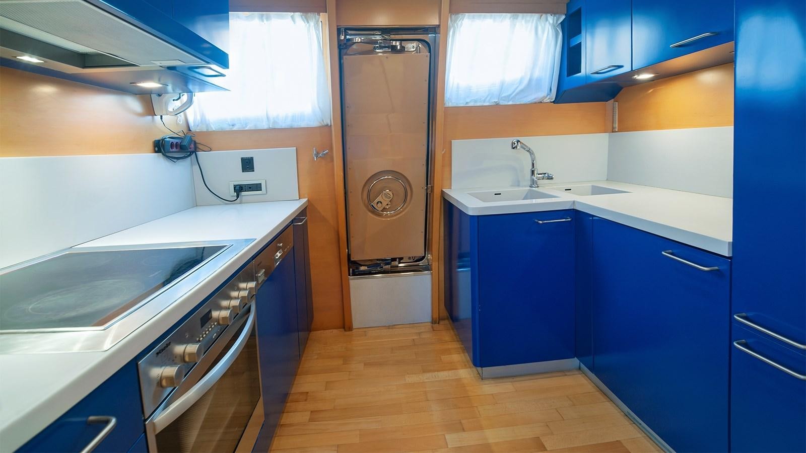 a kitchen with blue cabinets aboard AMYMONE Yacht for Sale