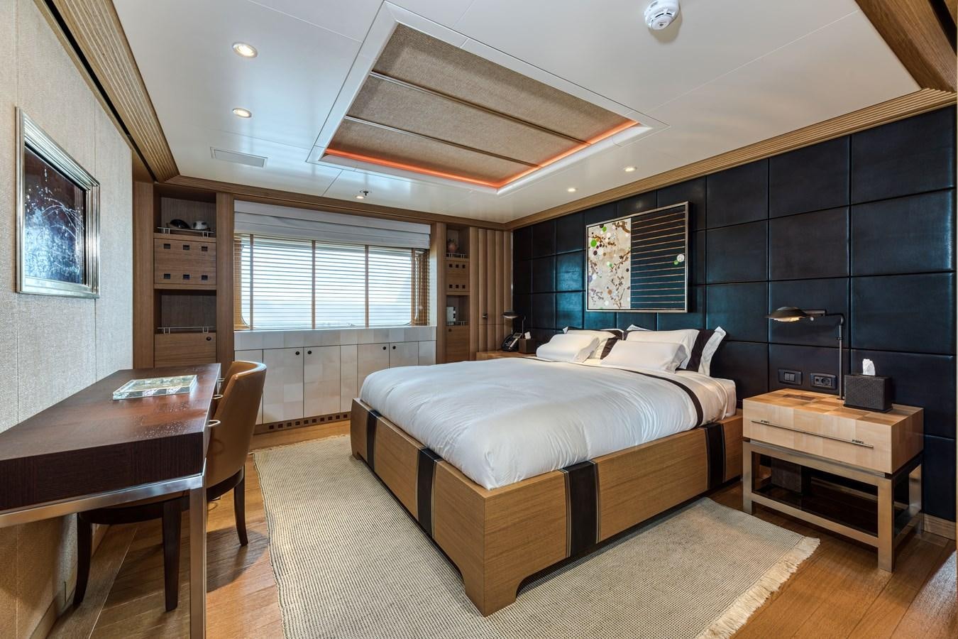 a bedroom with a bed and a desk aboard KOGO Yacht for Sale