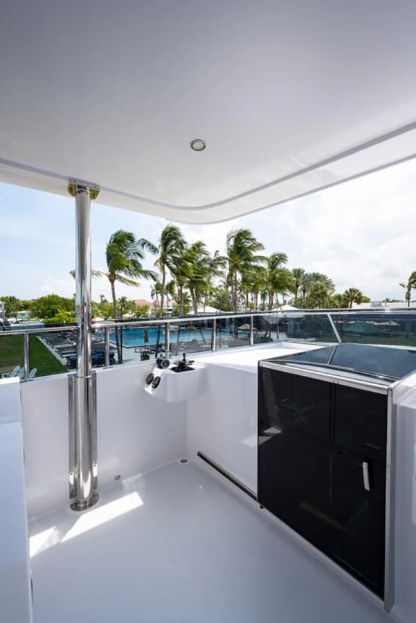 a white wall with a black and silver metal railing and a railing with trees and a building and aboard G120 SIGNATURE SERIES Yacht for Sale