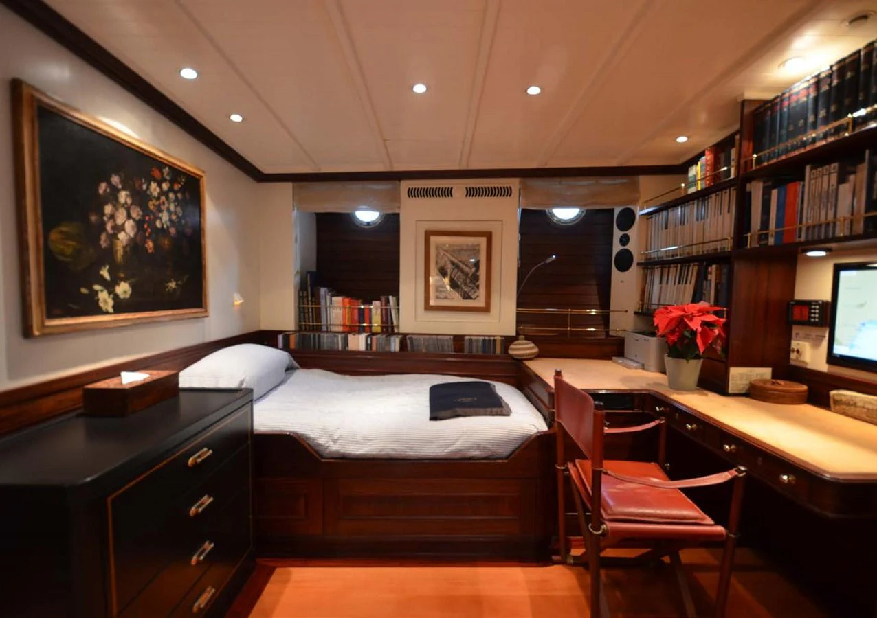 a bedroom with a bed and desk aboard SHENANDOAH OF SARK Yacht for Charter