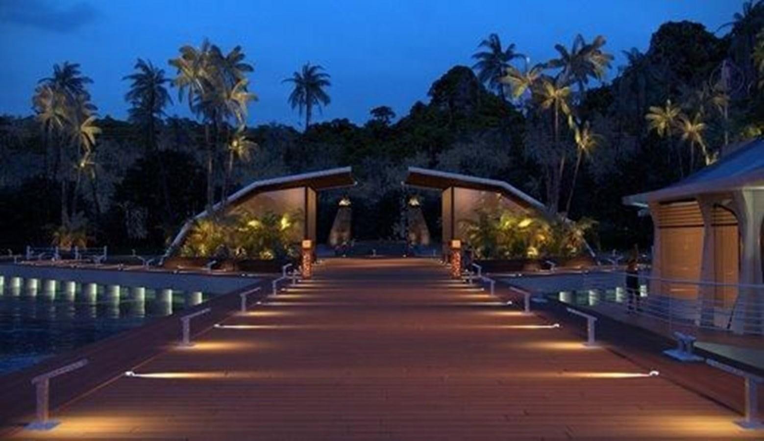 a pool with a bridge and palm trees at night aboard 2020 ORION ORSOS ISLAND Yacht for Sale