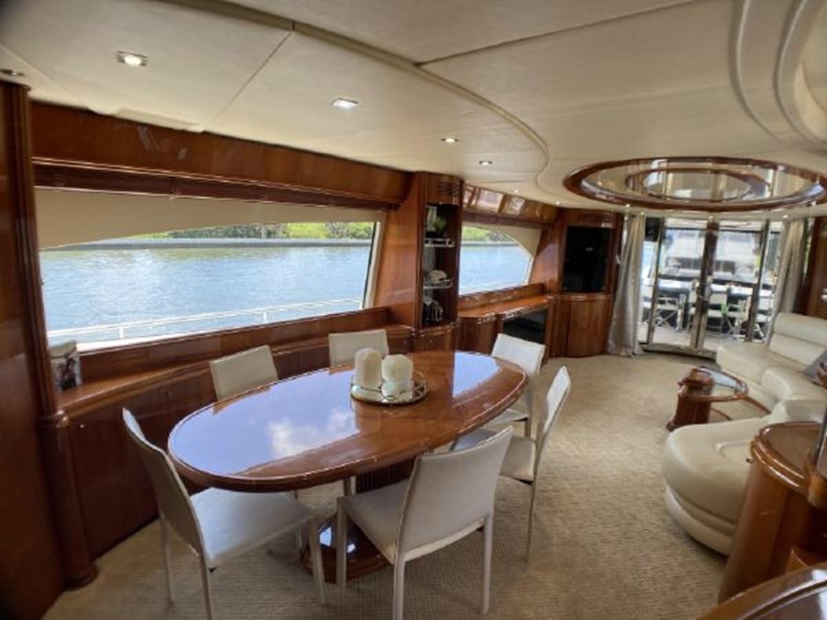 a dining table and chairs in a room with a large window aboard 85 AZIMUT ULTIMATE Yacht for Sale