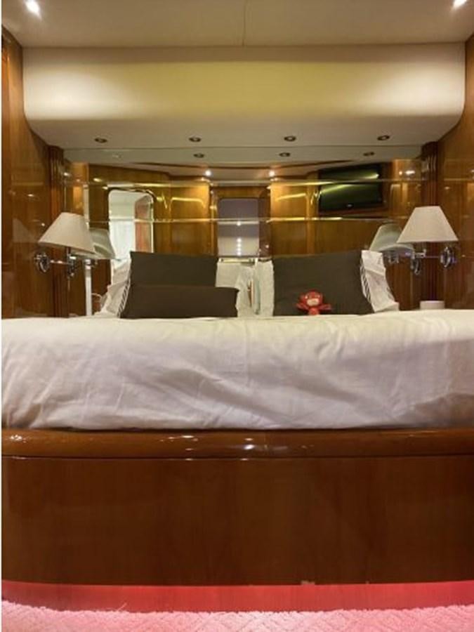 a bed with a white sheet and a black pillow on it aboard 85 AZIMUT ULTIMATE Yacht for Sale