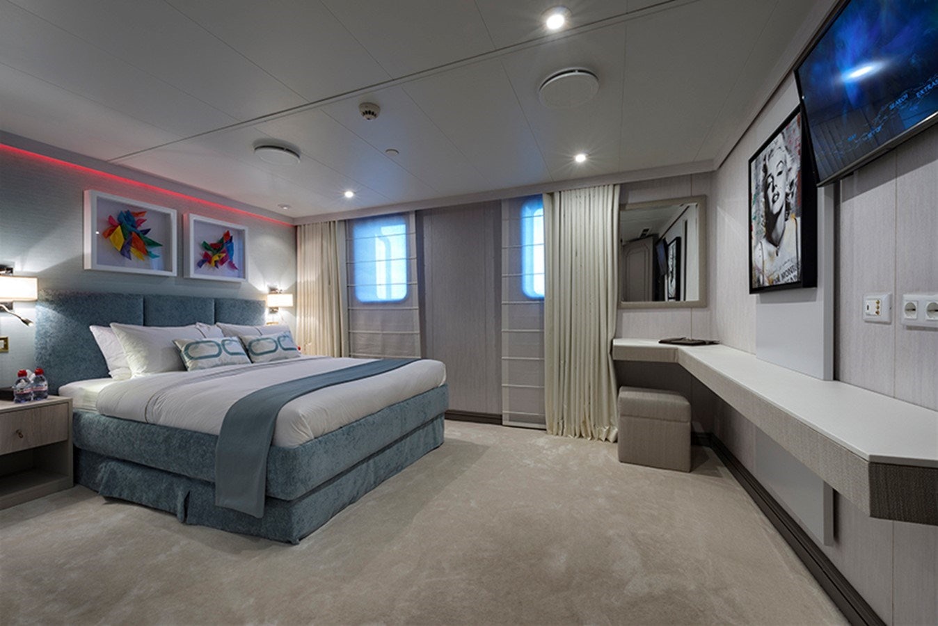 a bedroom with a bed and a desk aboard CHAKRA Yacht for Charter