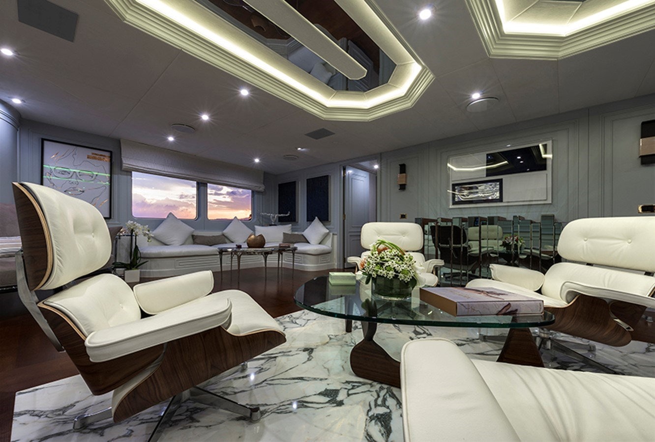 a living room with white couches and a large window aboard CHAKRA Yacht for Charter