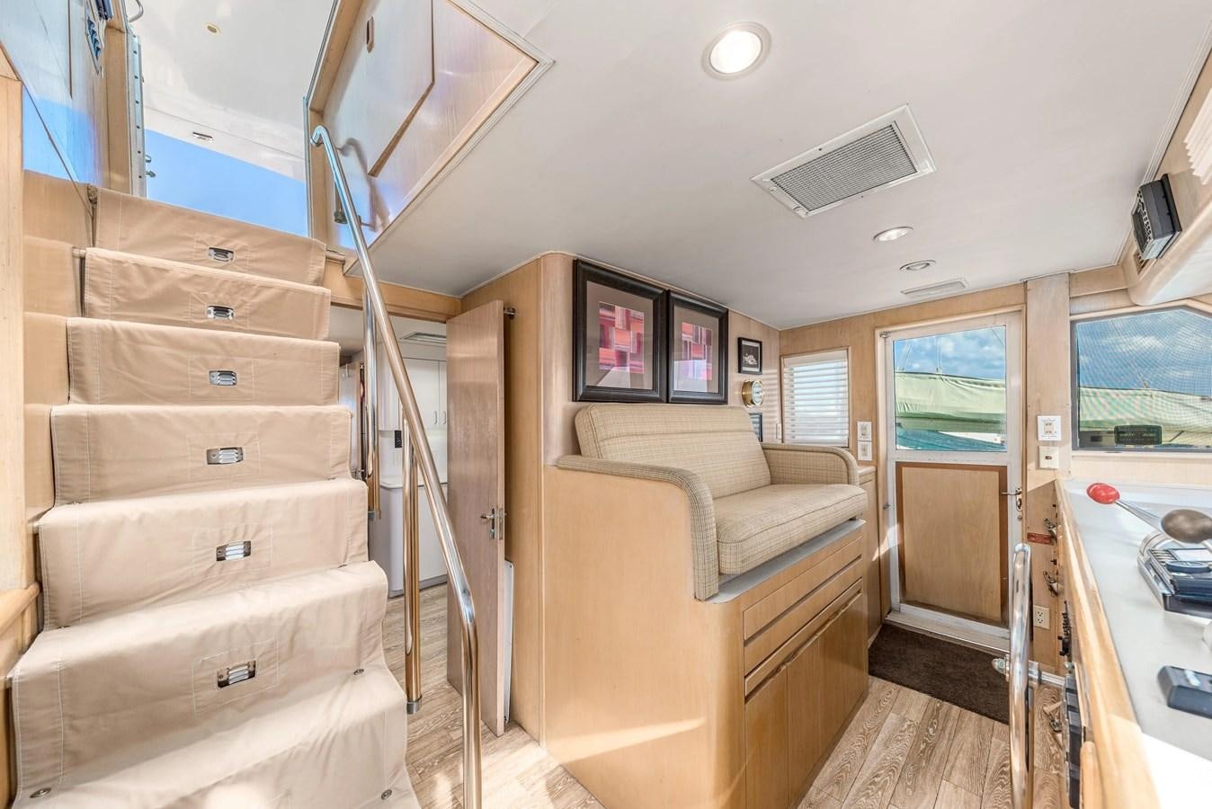 a small living room with a bunk bed and a large wood table aboard KALEVALA Yacht for Sale