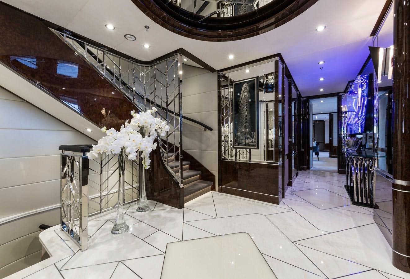 a large room with a staircase and flowers aboard SOUNDWAVE Yacht for Sale