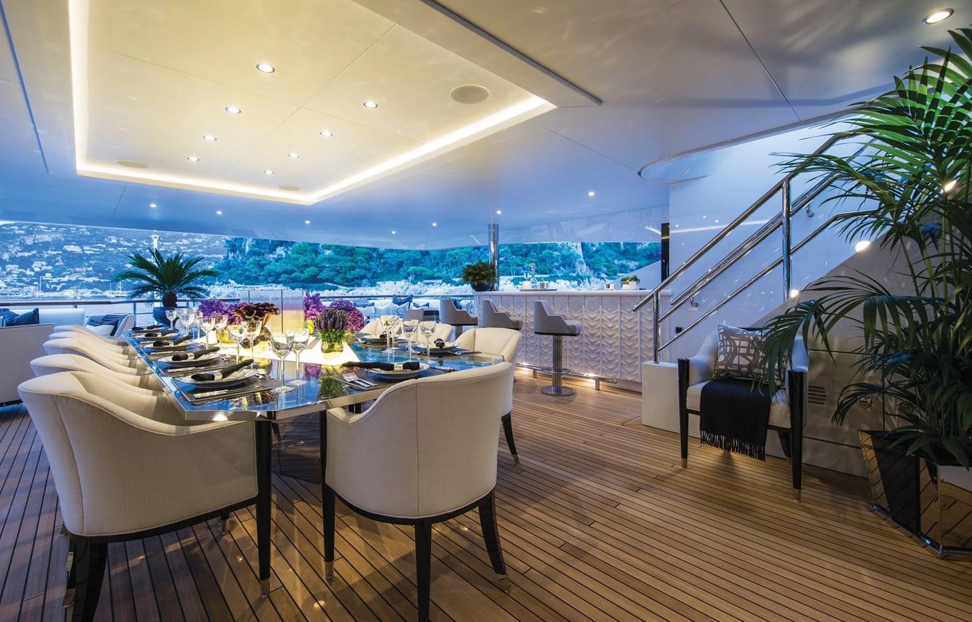 a room with a table chairs and plants aboard SOUNDWAVE Yacht for Sale