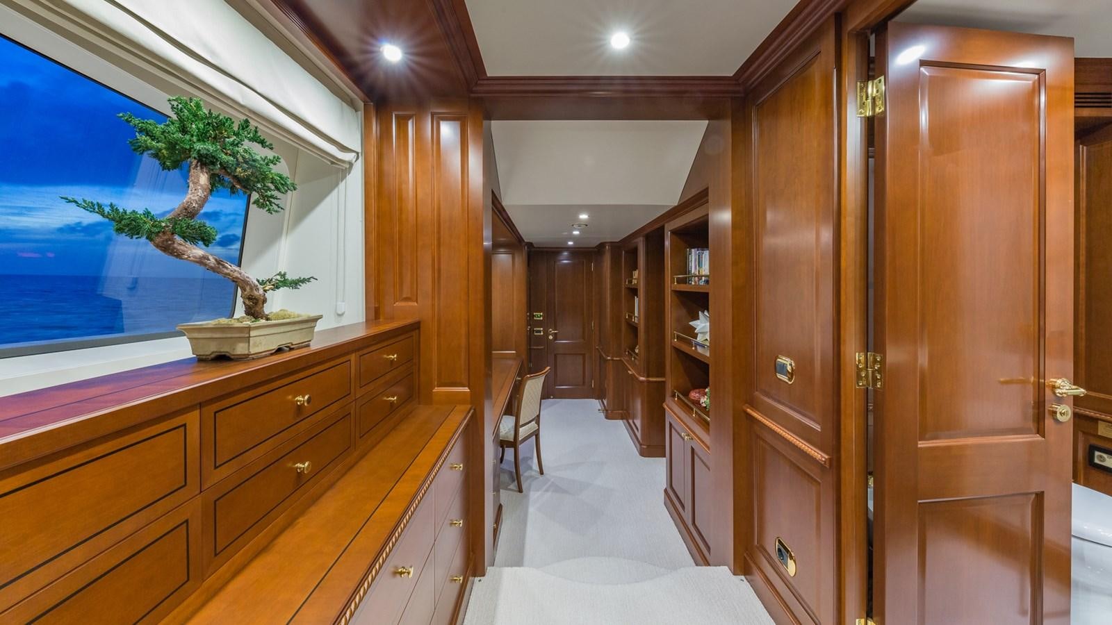 a room with wooden cabinets and a painting on the wall aboard NAMASTE Yacht for Sale