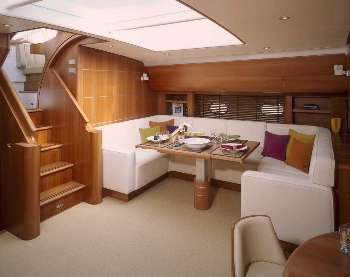 a room with a table and couch aboard MBOLO Yacht for Sale