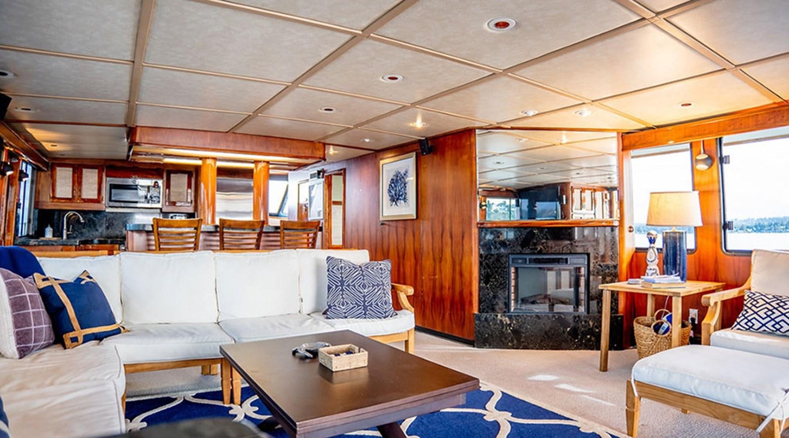 a living room with a fireplace aboard PACIFIC SHADOW Yacht for Sale