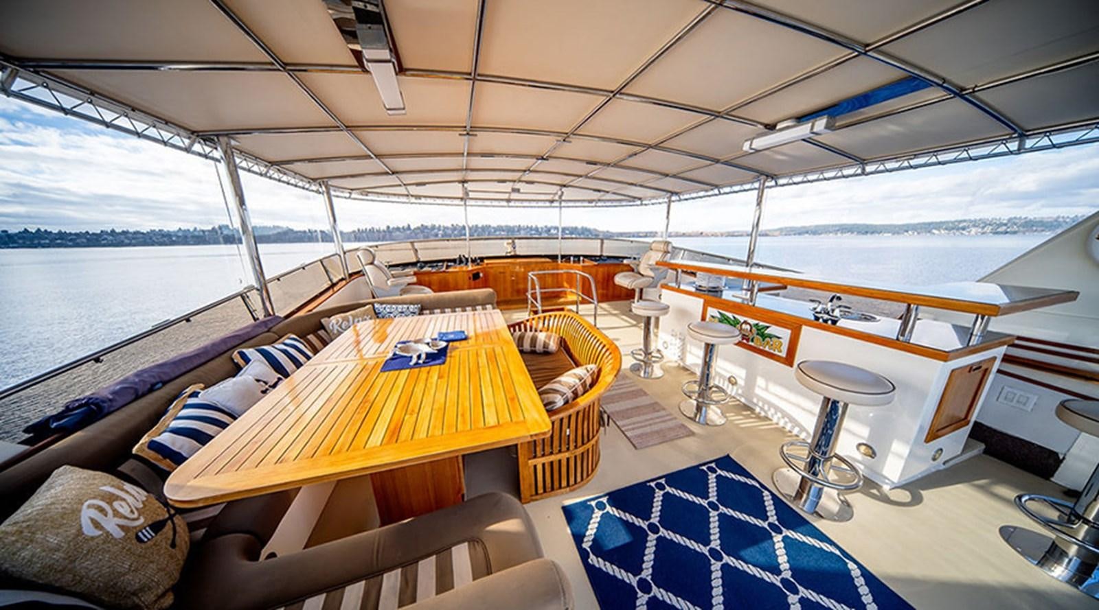 a boat with a table and chairs aboard PACIFIC SHADOW Yacht for Sale