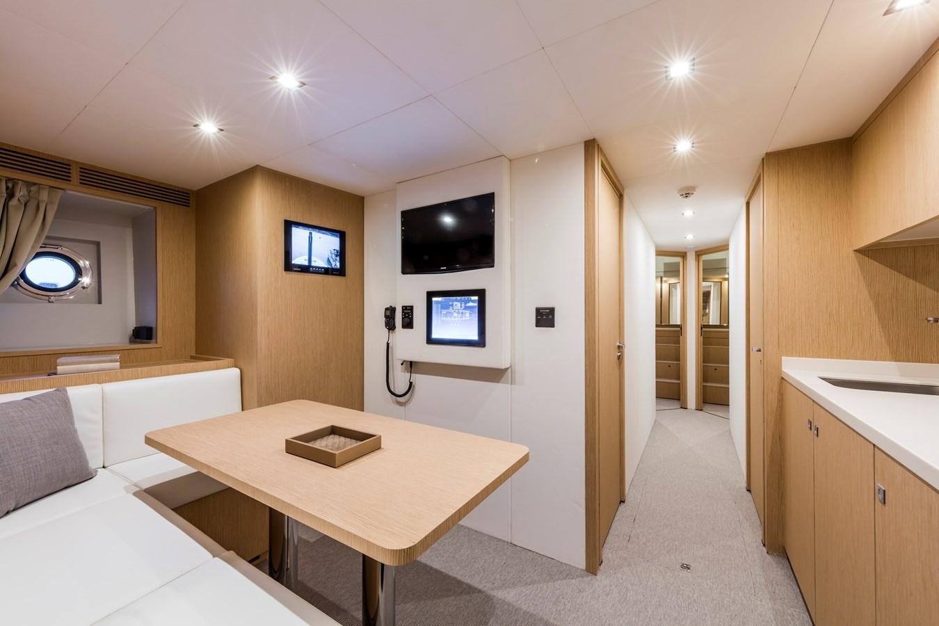 a room with a table and couch aboard NEVER BLUE Yacht for Sale