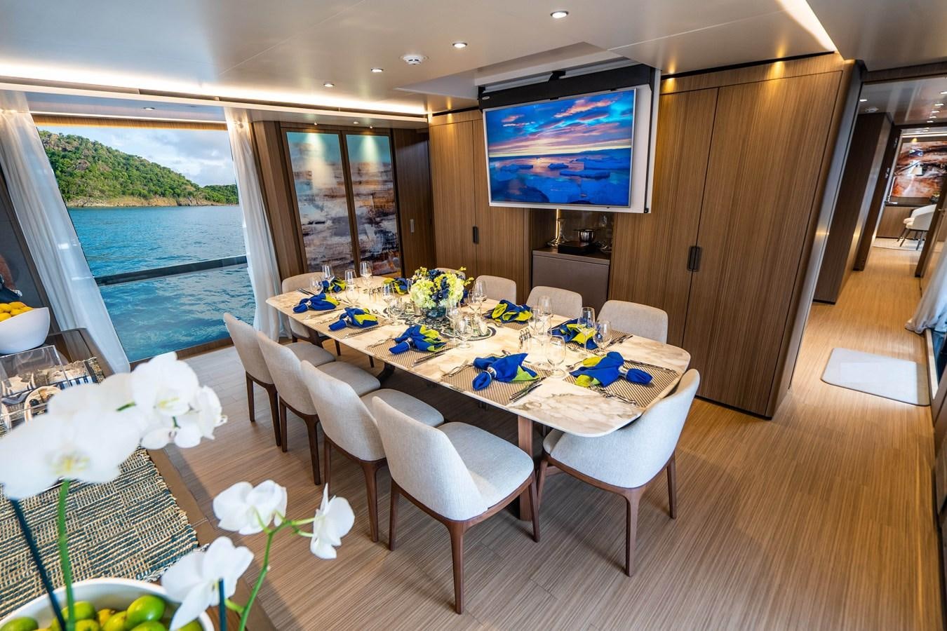 a room with tables and chairs aboard NEVER BLUE Yacht for Sale