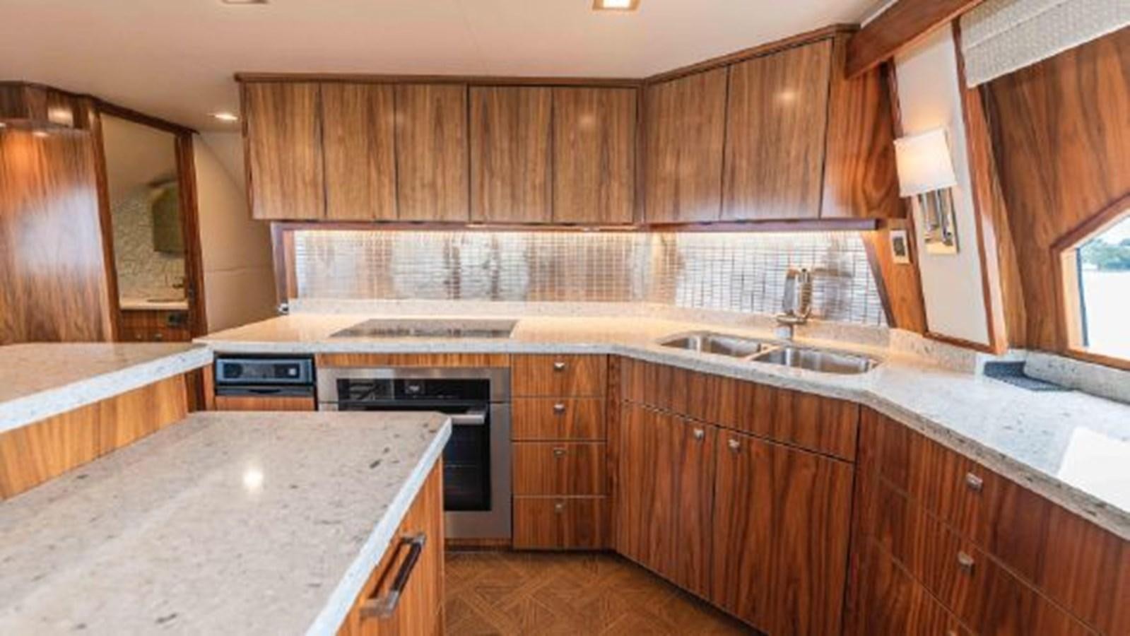 a kitchen with wooden cabinets aboard MAKARA Yacht for Sale