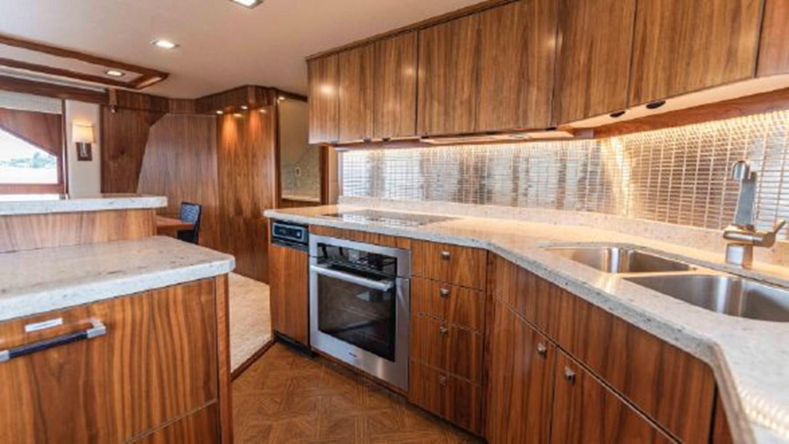 a kitchen with wooden cabinets aboard MAKARA Yacht for Sale