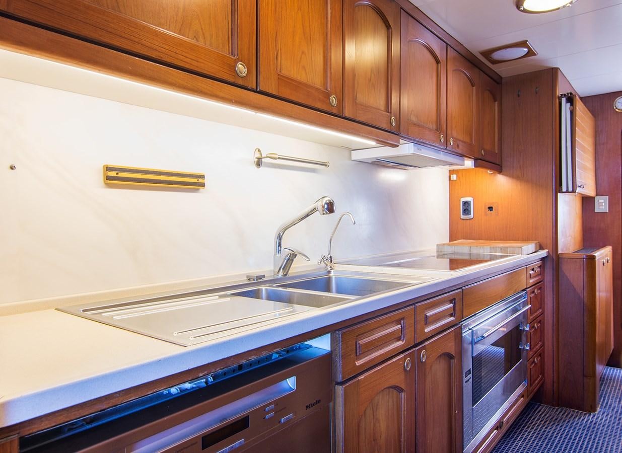 a kitchen with wooden cabinets aboard MOONSHADOW NOA Yacht for Sale