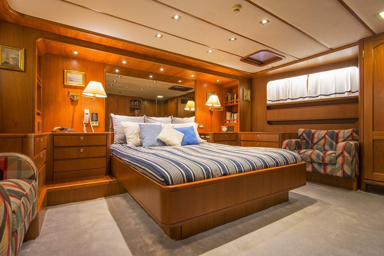 a room with a bed and a desk aboard MOONSHADOW NOA Yacht for Sale