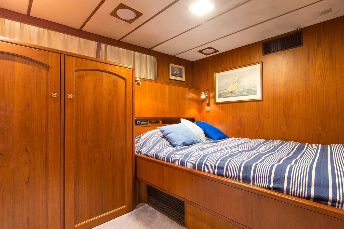 a room with a bed and a wood closet aboard MOONSHADOW NOA Yacht for Sale