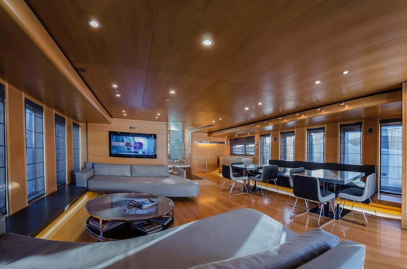 a large living room with a large screen and a large table aboard NOT GUILTY III Yacht for Sale