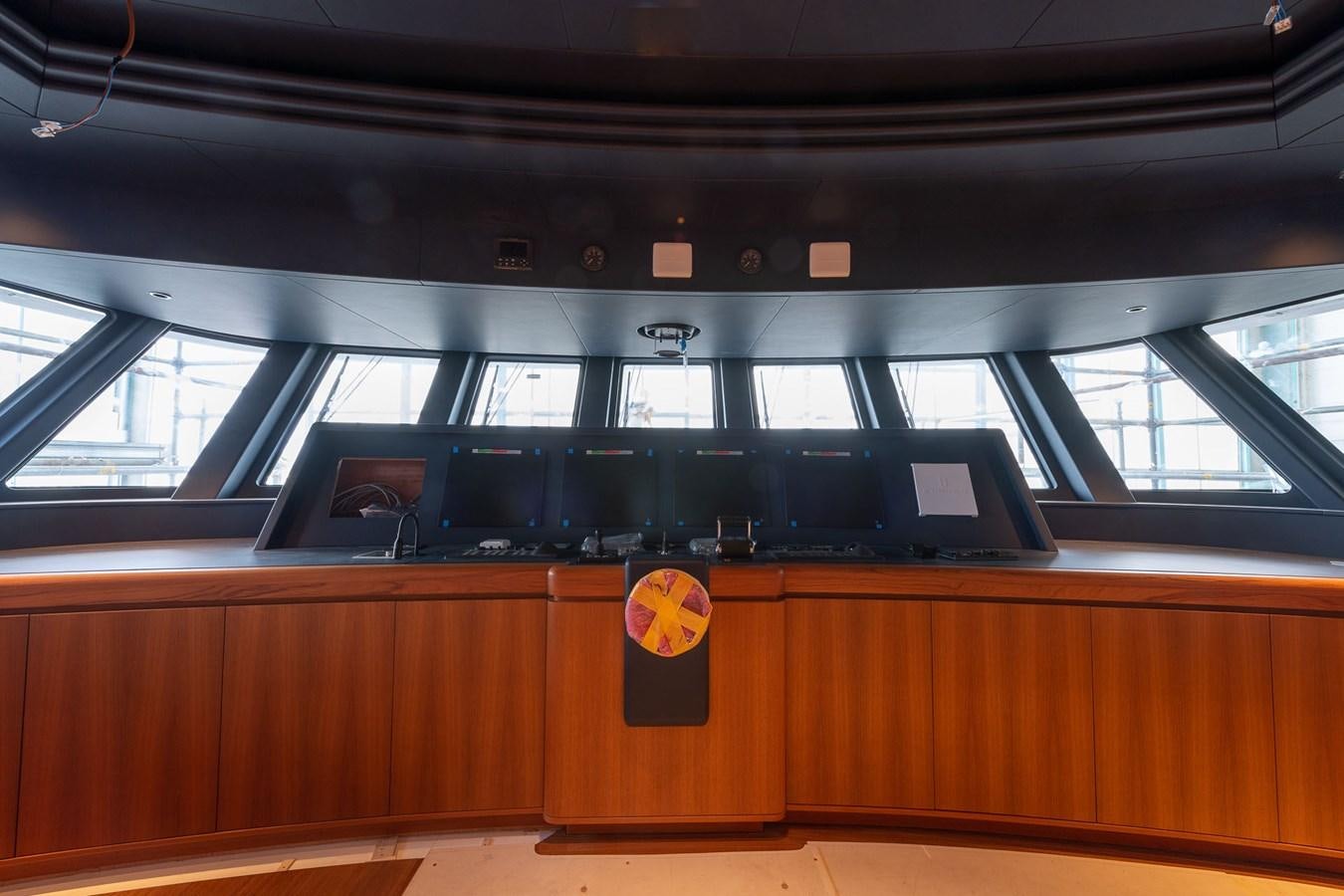 a black and yellow logo on a wooden desk aboard BARON TRENCK Yacht for Sale