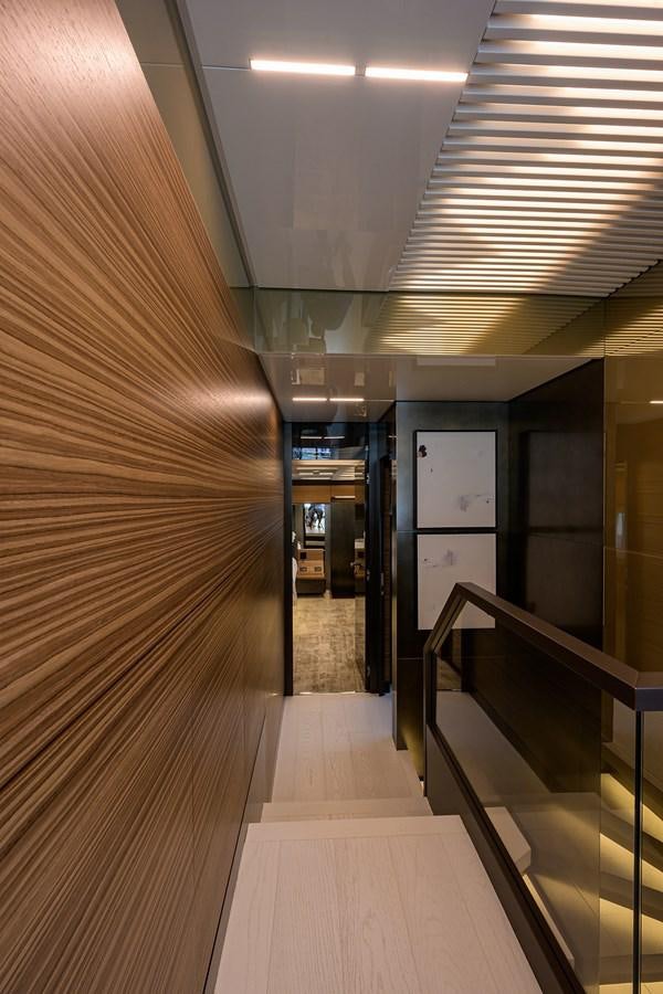 a hallway with a wood floor and a door with a railing aboard DATE NIGHT Yacht for Sale