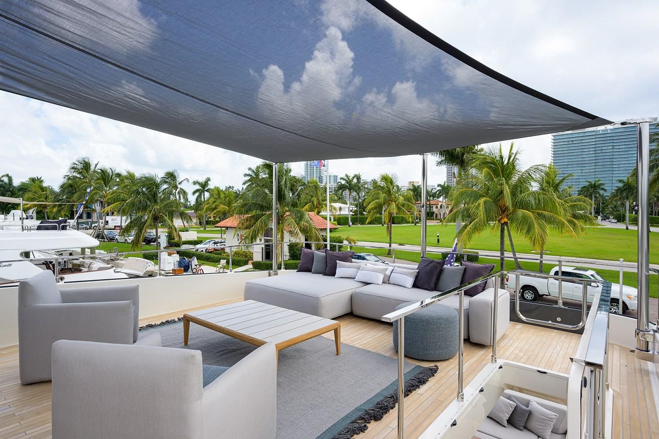a patio with a patio and lounge chairs and a large umbrella aboard DATE NIGHT Yacht for Sale