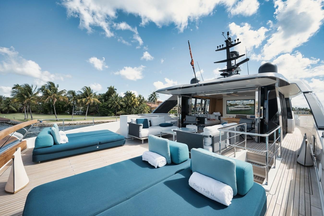 a pool with lounge chairs and a large metal statue on the deck aboard DON'T TELL MOM  Yacht for Sale