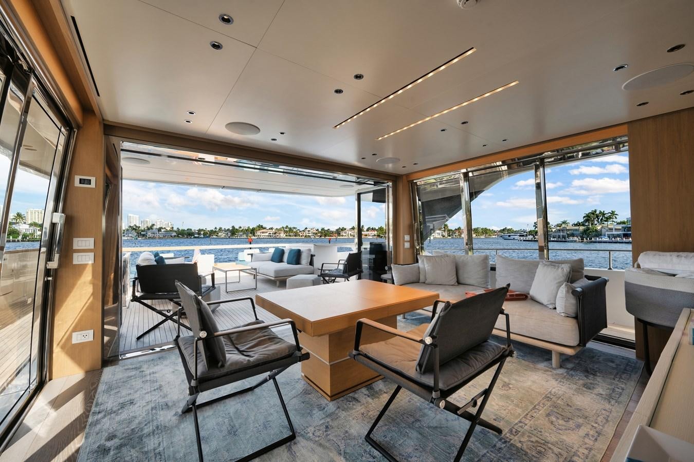 a room with a table chairs and a view of the water aboard DON'T TELL MOM  Yacht for Sale