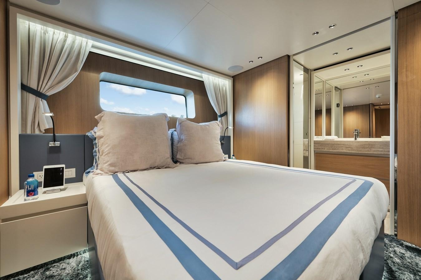 a bed with a blue and white comforter and pillows aboard DON'T TELL MOM  Yacht for Sale