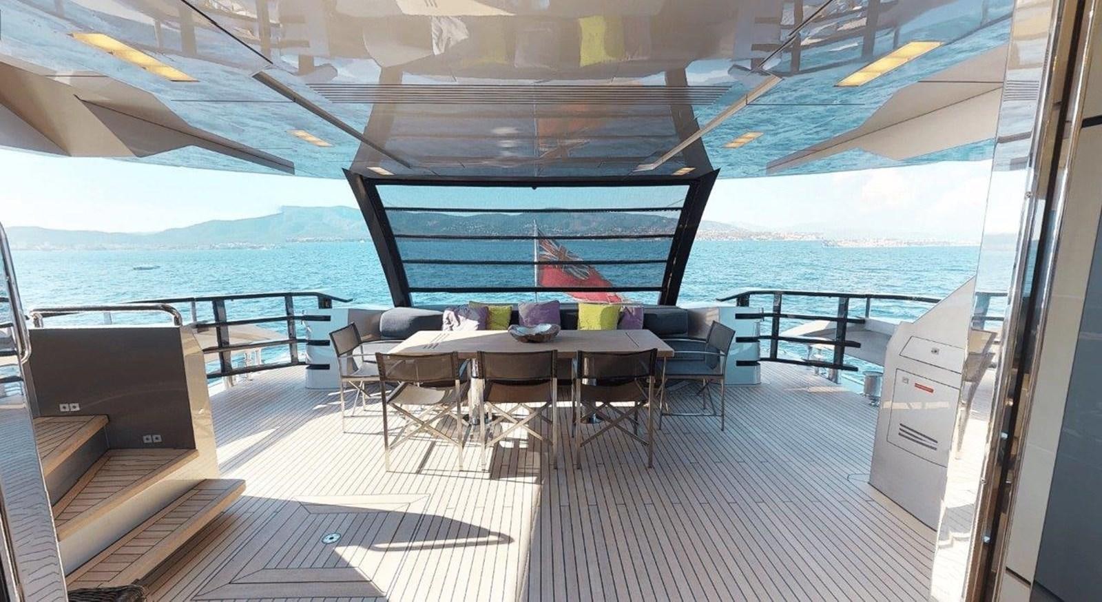 a deck with a table and chairs aboard FUSION Yacht for Charter