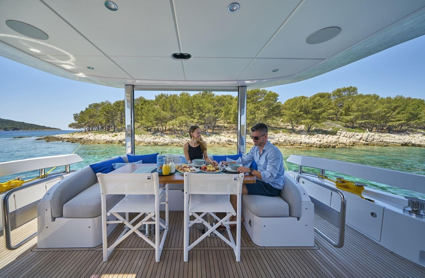 a couple sitting at a table on a boat aboard VIVA Yacht for Sale