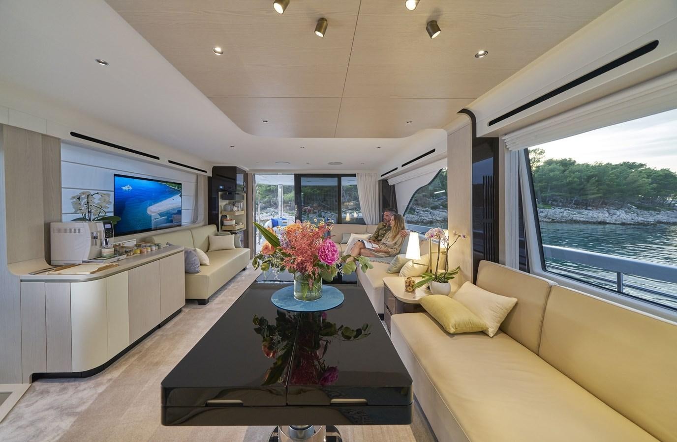 a person sitting on a couch in a living room aboard VIVA Yacht for Sale
