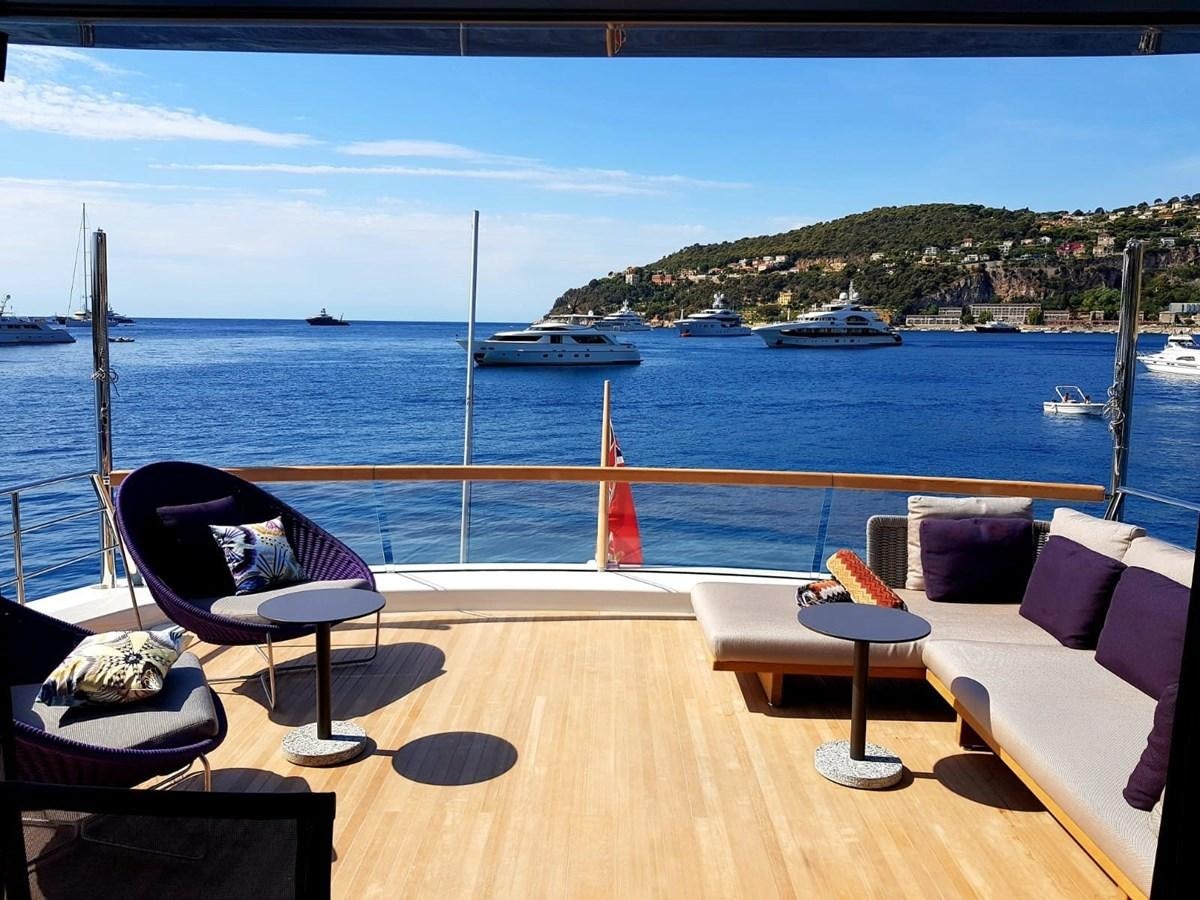 a deck with chairs and tables on it by the water aboard 2020 SANLORENZO SX88 #43 Yacht for Sale