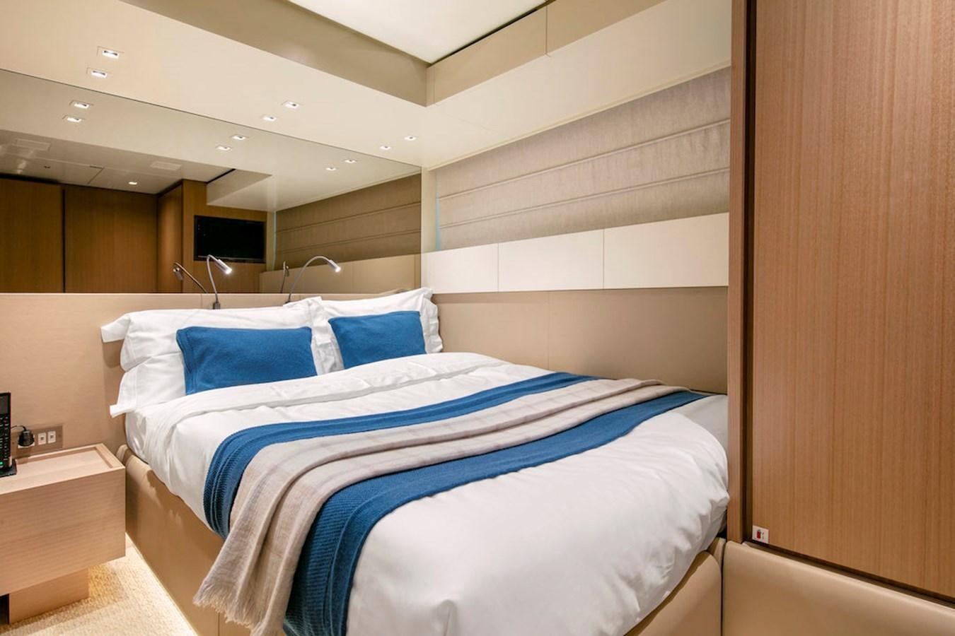 a bed with a blue and white bed spread aboard SX88 Yacht for Sale
