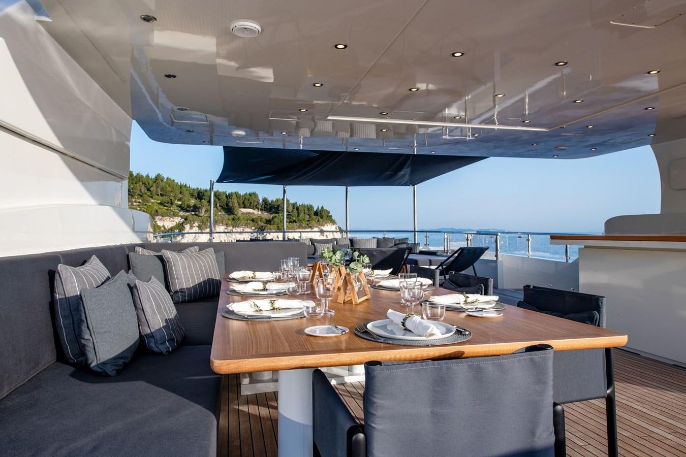 a table with plates and chairs aboard ZIA Yacht for Sale