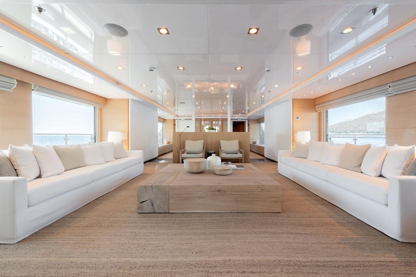 a large living room with white couches and a large window aboard ZIA Yacht for Sale