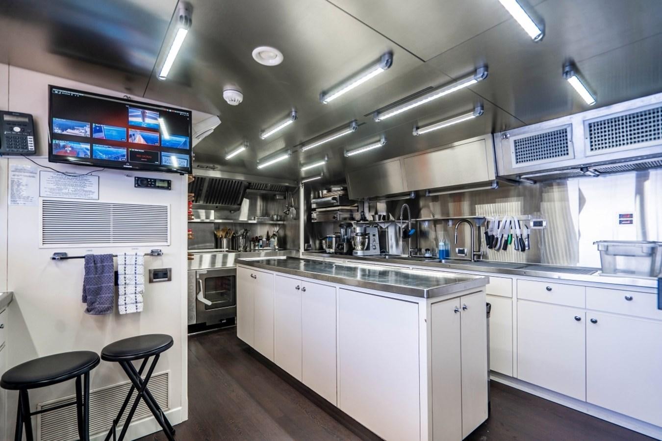 a kitchen with white cabinets aboard DRAMA QUEEN Yacht for Sale