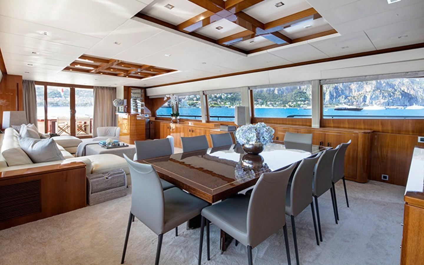 a large dining table in a living room aboard NYOTA Yacht for Charter