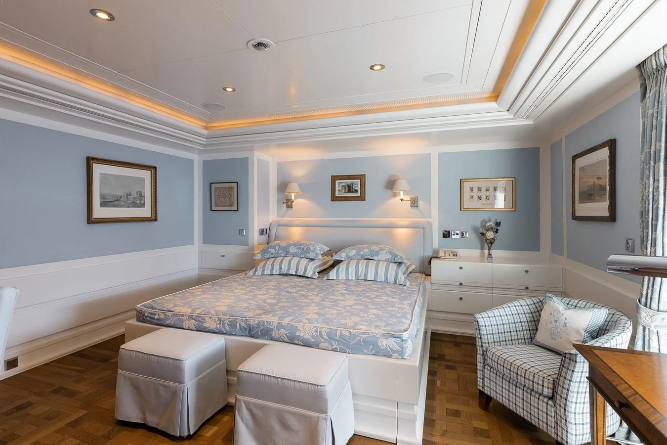 a bedroom with a bed and a chair aboard CARINTHIA VII Yacht for Charter