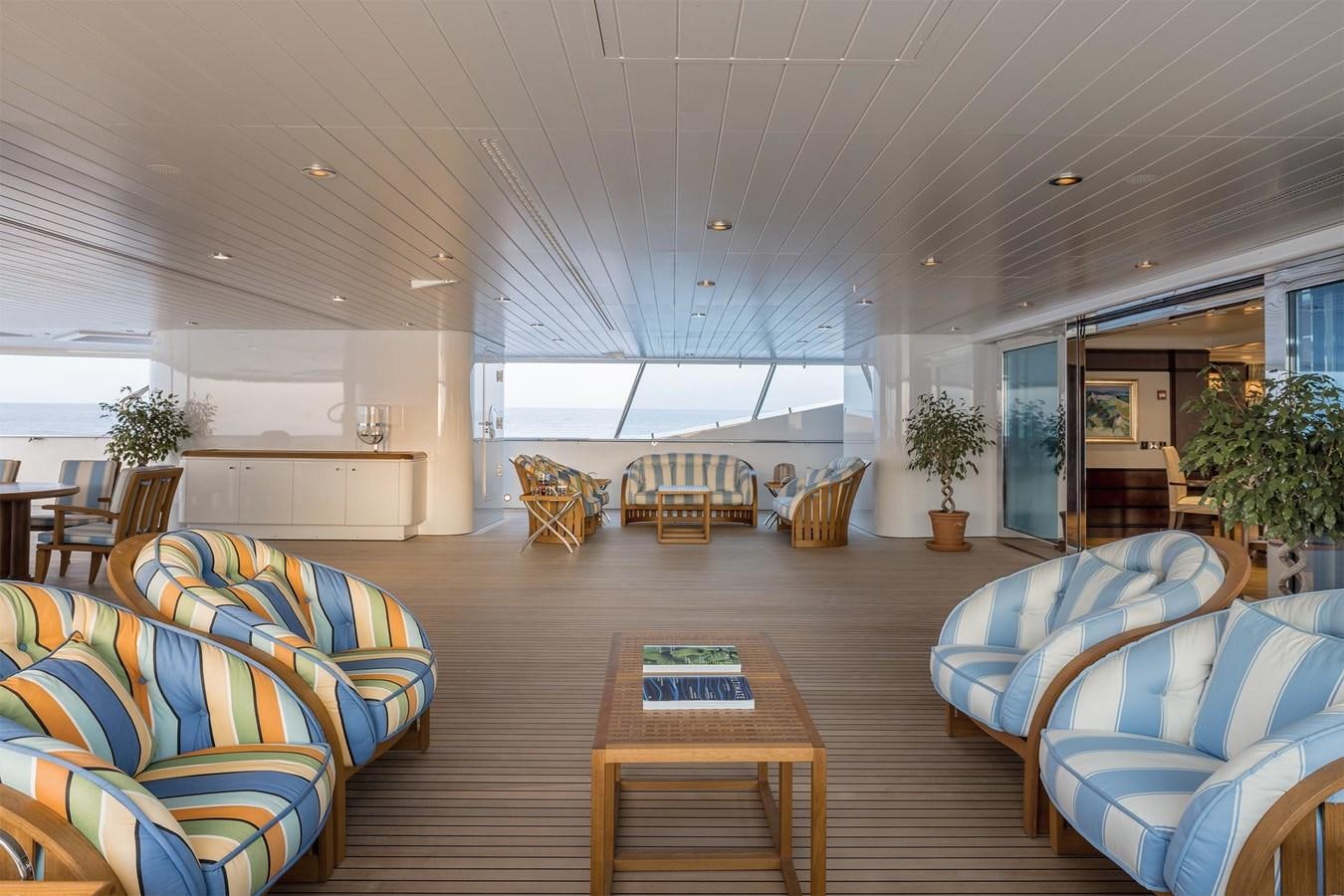 a large living room with a wood floor and a wood table aboard CARINTHIA VII Yacht for Sale
