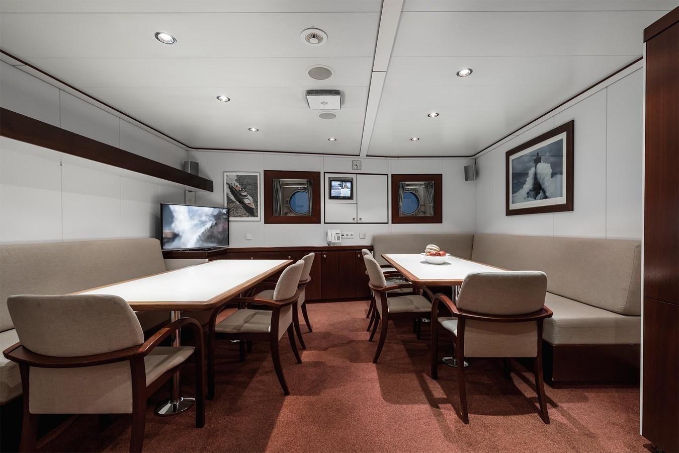 a room with tables and chairs aboard CARINTHIA VII Yacht for Sale