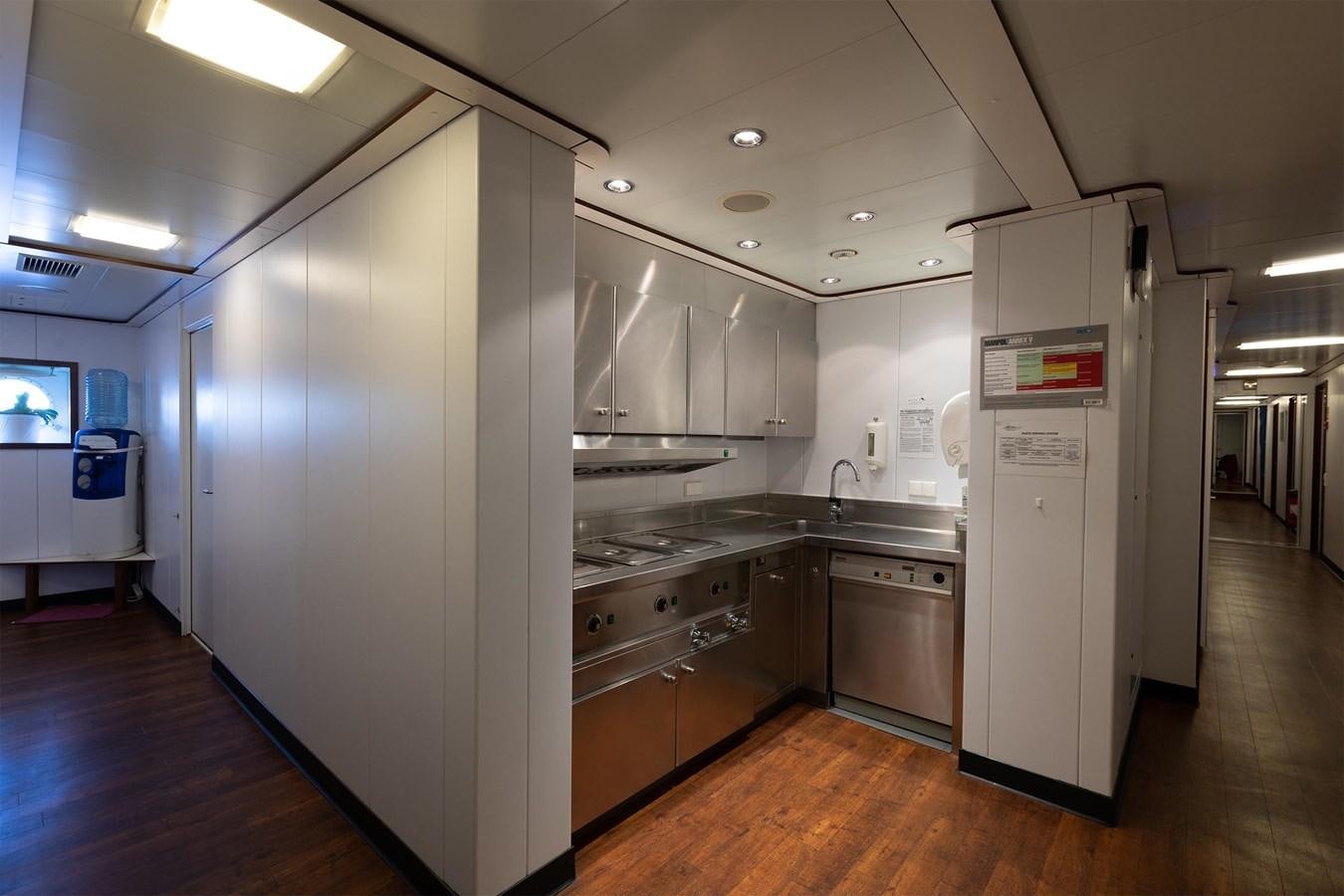 a large kitchen with white cabinets aboard CARINTHIA VII Yacht for Sale